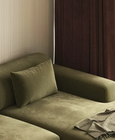Olive velvet sofa against a timber-panelled wall and burgundy curtain